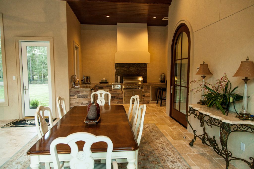 Large outdoor living area with custom built outdoor kitchen/grill area and large fireplace.
