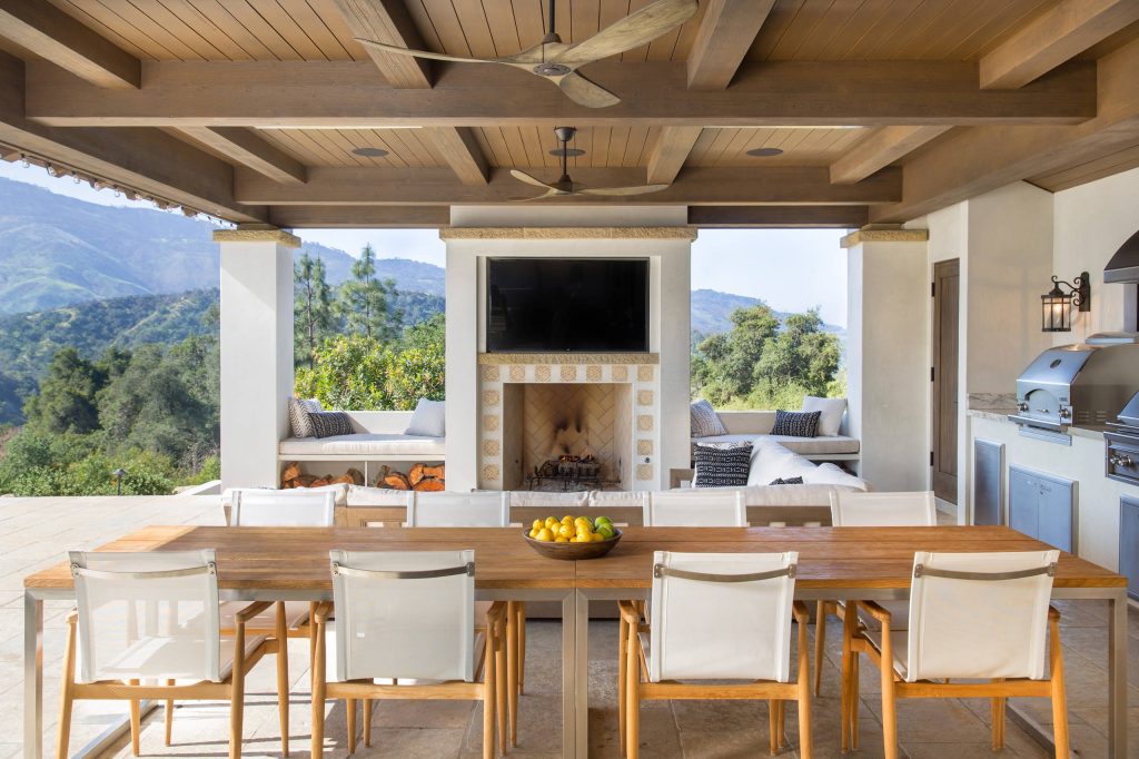 Large outdoor patio provides seating by fireplace and outdoor dining with bbq and grill.