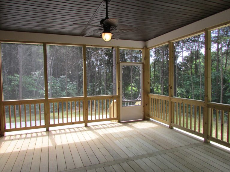 Large screened porch with dual exits leading to the patio and wooded yard