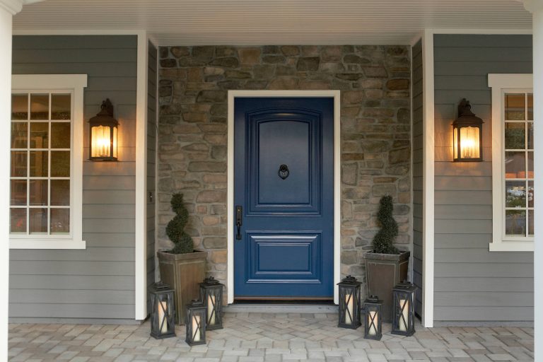 Large single entry door in Blue with coach lights.