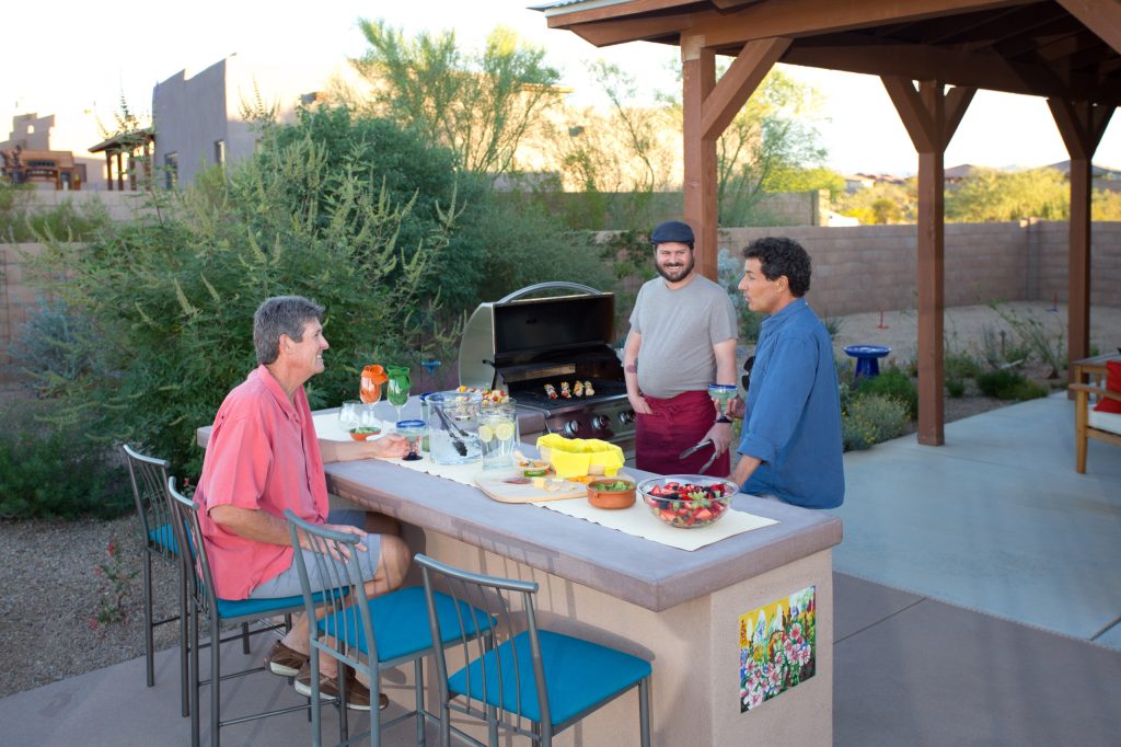 Large southwest backyard concrete patio kitchen photo in Phoenix with a roof extension