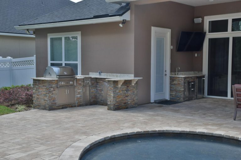 Large transitional backyard concrete paver patio kitchen photo in Jacksonville with a roof extension