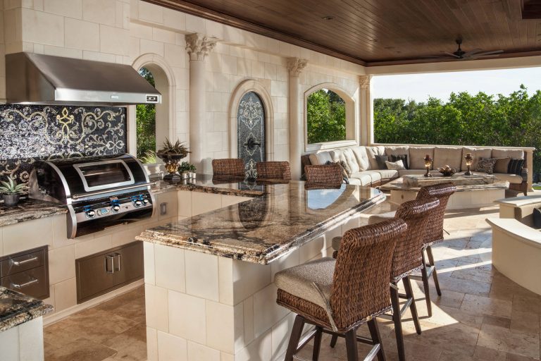 Large transitional backyard outdoor kitchen deck photo in Los Angeles with a roof extension