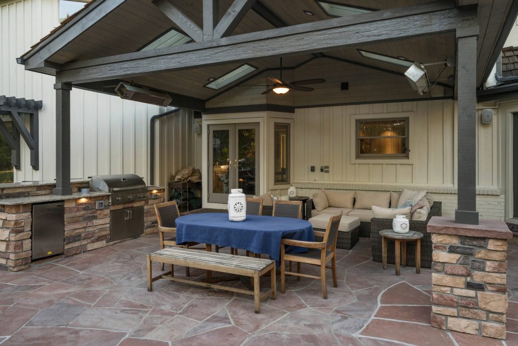 Large transitional backyard stone patio kitchen photo in Denver with a roof extension