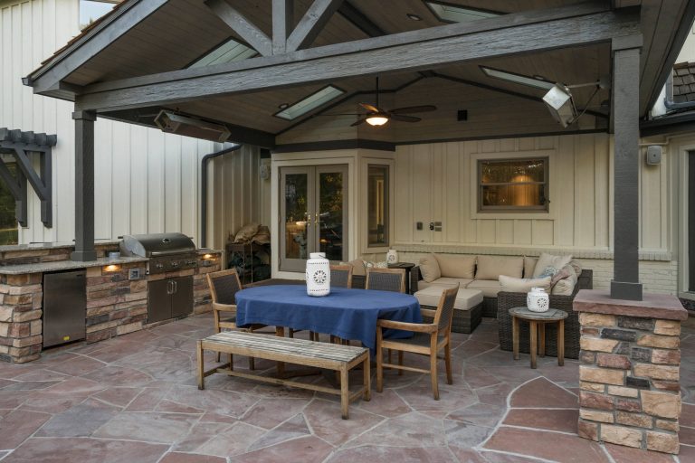 Large transitional backyard stone patio kitchen photo in Denver with a roof extension