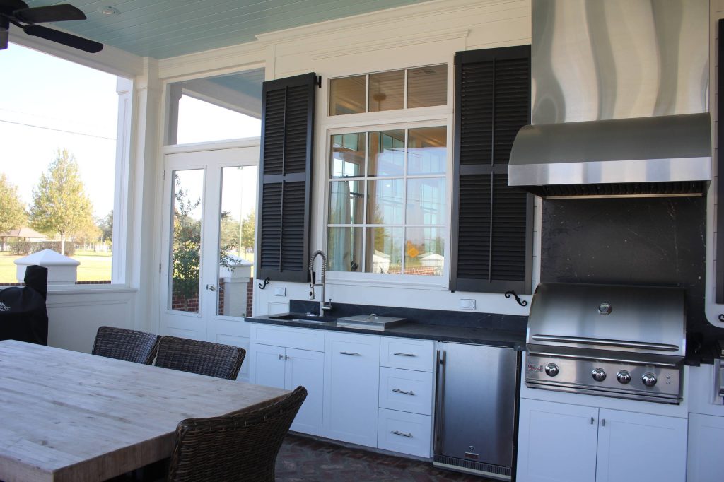 Large transitional backyard tile patio kitchen photo in New Orleans with a roof extension