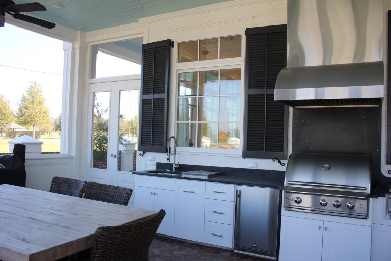Large transitional backyard tile patio kitchen photo in New Orleans with a roof extension