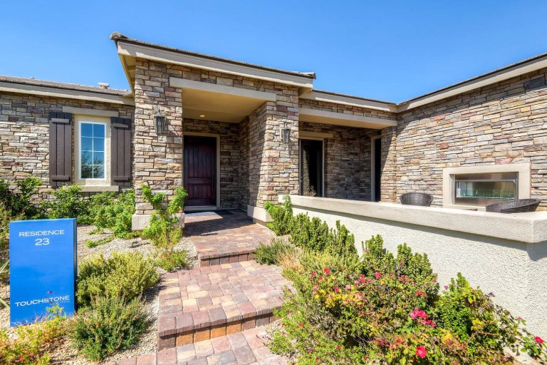 Large transitional brick front porch idea in Las Vegas with a fire pit and a roof extension by Touchstone Living | Outdoor Photos | Porch | Landscaping | Landscape Design | Outdoor Living Space | Porch Design Ideas | Outdoor Living Space Ideas | Backyard Design