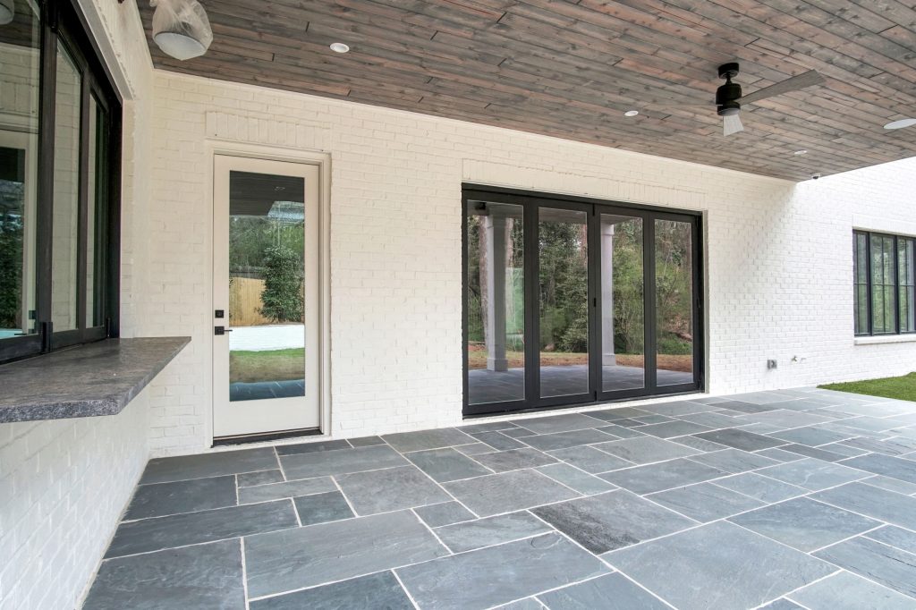 Large transitional stone porch photo in Atlanta with a roof extension