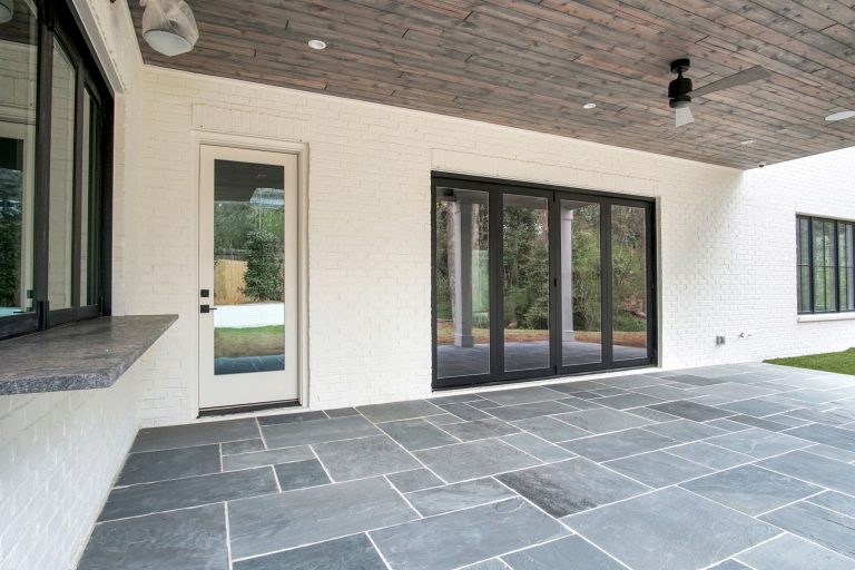 Large transitional stone porch photo in Atlanta with a roof extension