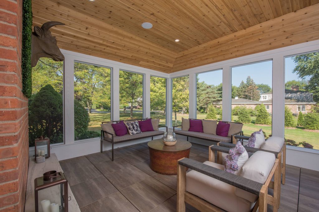 Large transitional stone screened-in side porch photo in Chicago with a roof extension by A. Perry Homes | Outdoor Photos | Porch | Landscaping | Landscape Design | Outdoor Living Space | Porch Design Ideas | Outdoor Living Space Ideas | Backyard Design