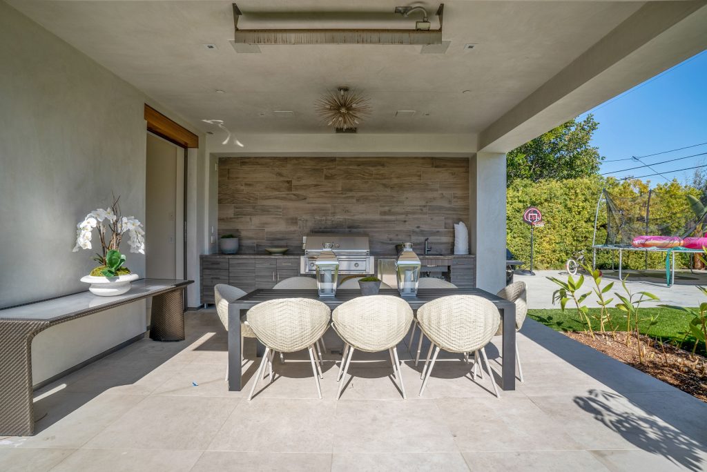 Large trendy backyard concrete paver patio kitchen photo in Los Angeles with a roof extension