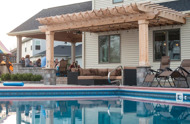 Large trendy backyard concrete paver patio kitchen photo in Other with a pergola