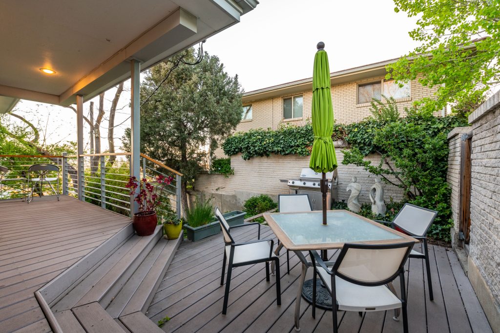 Large trendy backyard metal railing deck photo in Salt Lake City with a roof extension
