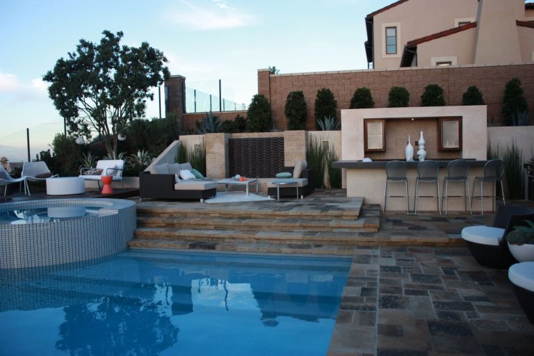 Large trendy backyard stone patio kitchen photo in Orange County with a pergola