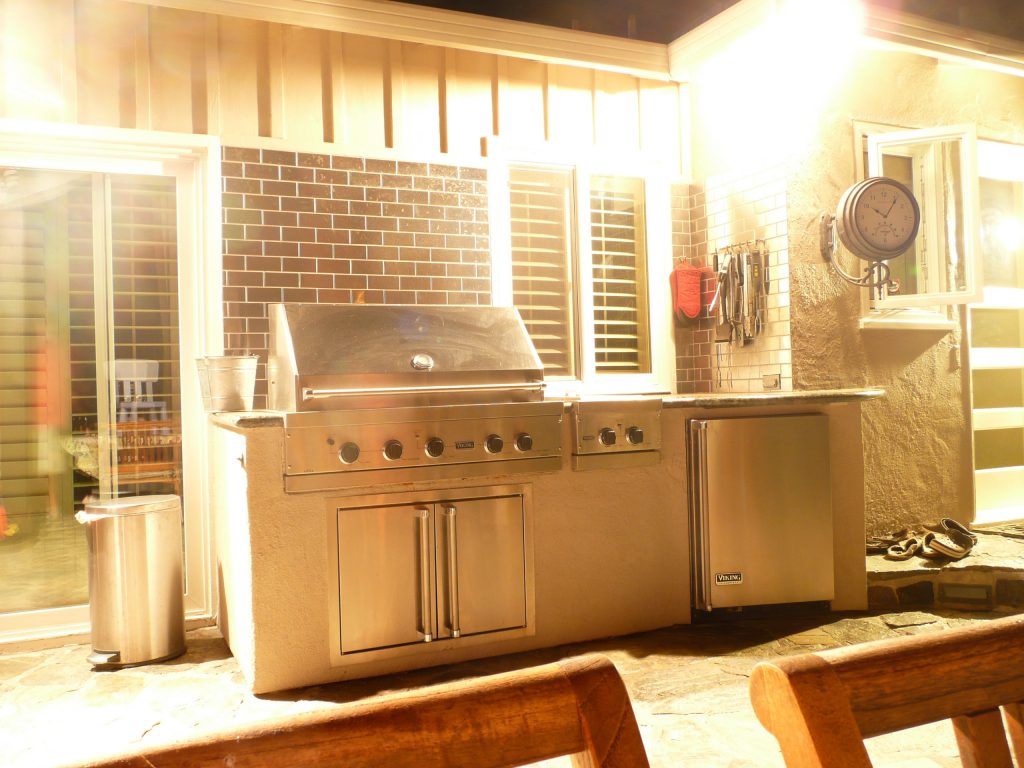 Large trendy backyard stone patio kitchen photo in Portland with a pergola