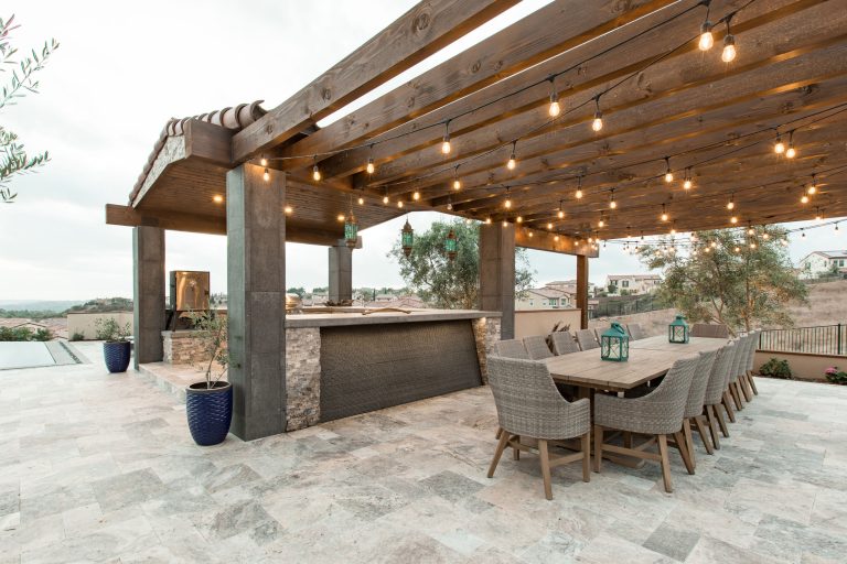 Large trendy backyard stone patio kitchen photo in San Diego with a pergola