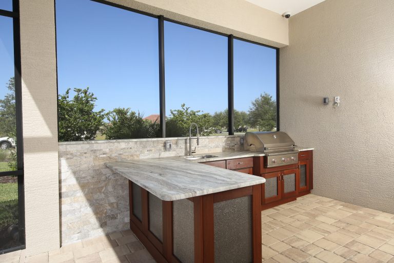 Large trendy backyard stone patio kitchen photo in Tampa with a roof extension