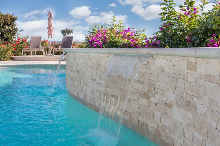 Large trendy backyard tile and custom-shaped pool fountain photo in Orange County