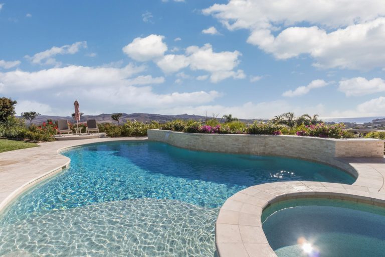 Large trendy backyard tile and custom-shaped pool fountain photo in Orange County