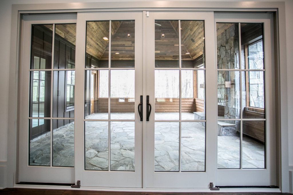 Large trendy stone screened-in back porch idea in Other with a roof extension by Milestone Custom Homes | Outdoor Photos | Porch | Landscaping | Landscape Design | Outdoor Living Space | Porch Design Ideas | Outdoor Living Space Ideas | Backyard Design