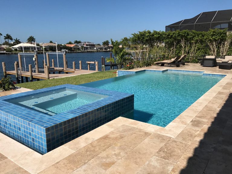 Large tuscan backyard stone pool photo in Miami
