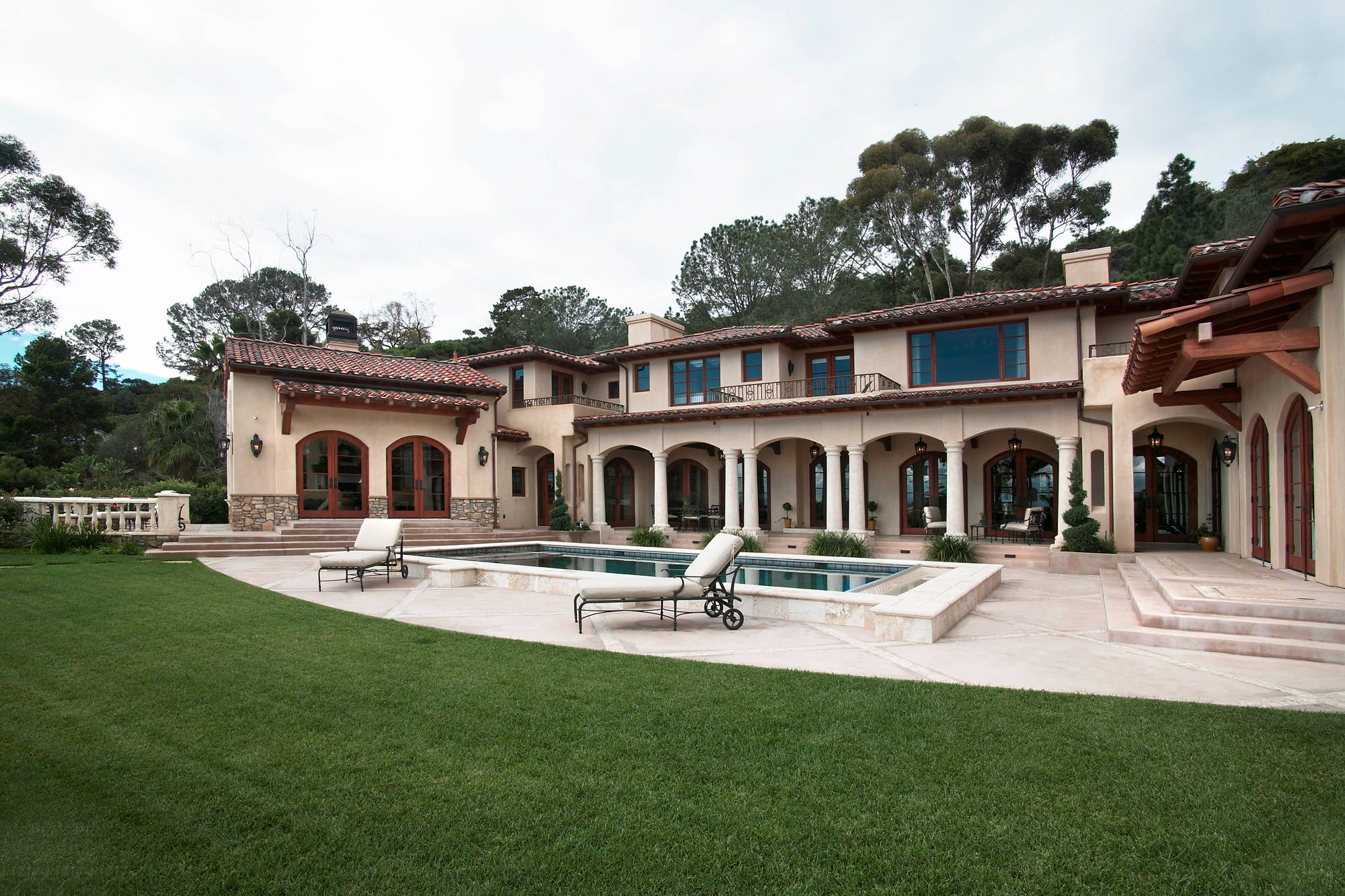 Large tuscan courtyard stone and rectangular pool house photo in San Diego