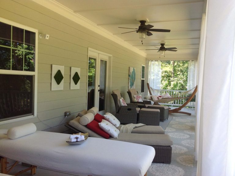 Long second floor porch with dining and lounging areas.