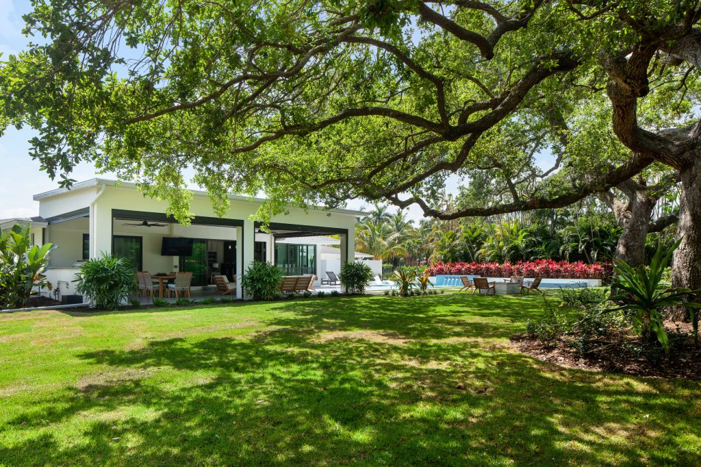 Mid- Century Home renovation. Added a covered lanai complete with an outdoor kitchen and automatic insect screens. Custom pool, tropical landscaping, and fire features. by Knaak Design Group | Outdoor Kitchens | Backyard Design | Outdoor Living Spaces | Landscape Design