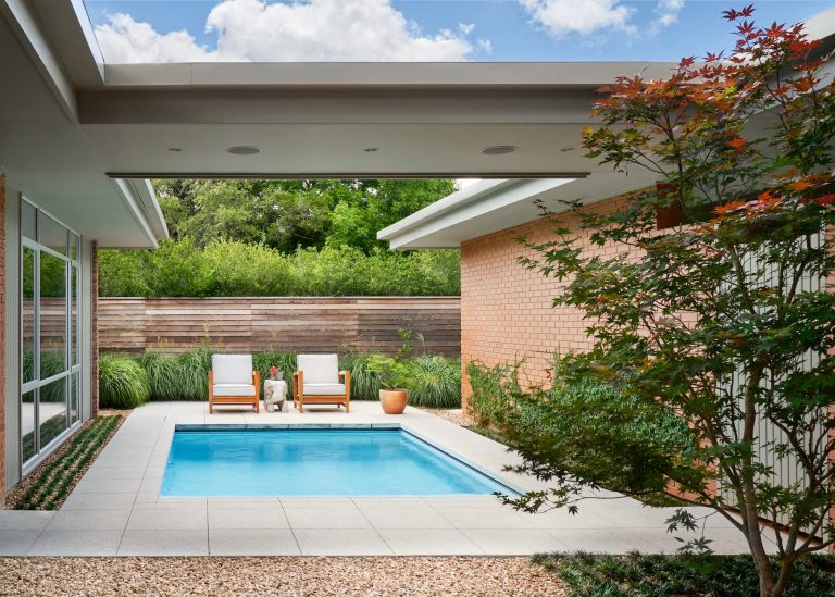 Mid-sized 1960s side yard concrete paver and rectangular pool photo in Austin