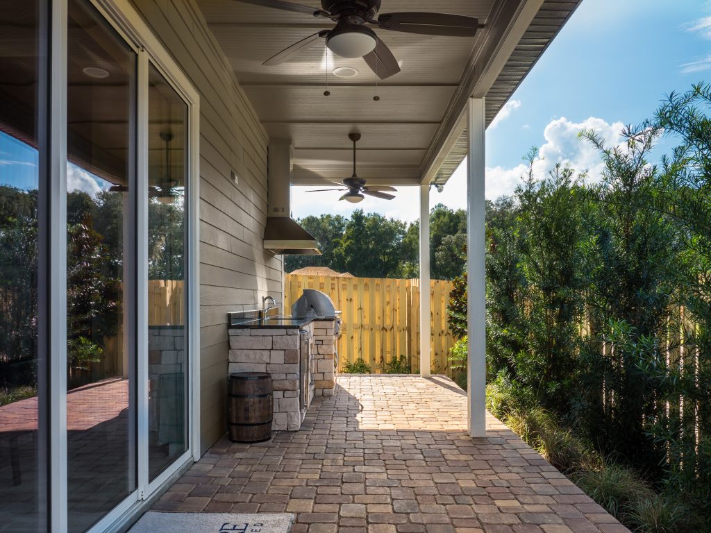 Mid-sized arts and crafts backyard concrete paver patio kitchen photo in Miami with an awning