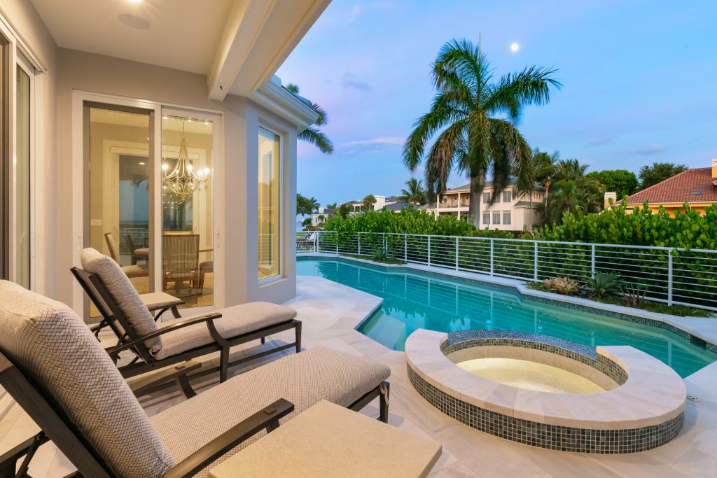 Mid-sized beach style backyard stone and custom-shaped lap hot tub photo in Tampa