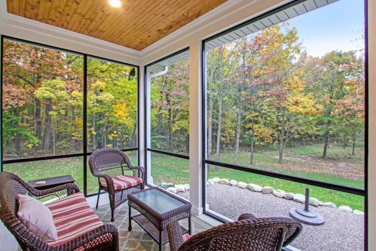 Mid-sized concrete screened-in back porch photo in Grand Rapids with a roof extension by Hauschild Custom Builders | Outdoor Photos | Porch | Landscaping | Landscape Design | Outdoor Living Space | Porch Design Ideas | Outdoor Living Space Ideas | Backyard Design