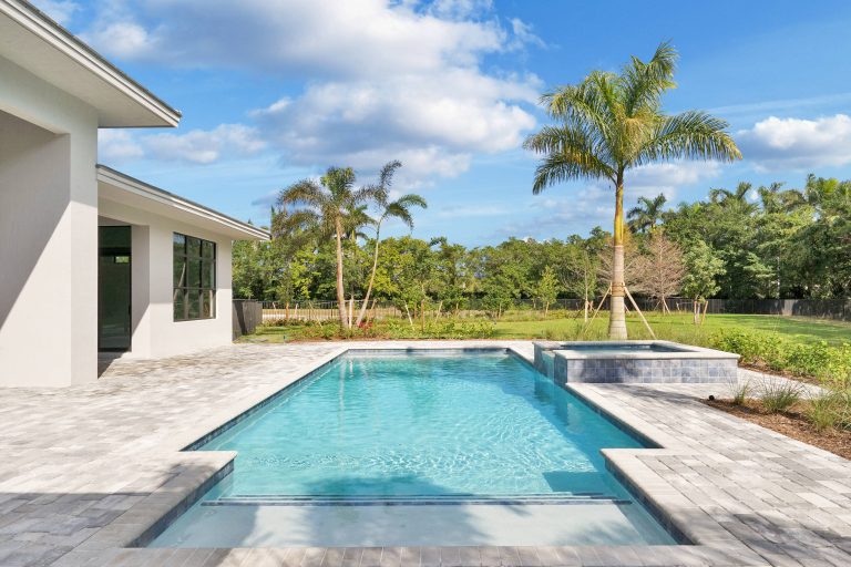 Mid-sized elegant backyard brick and rectangular lap hot tub photo in Miami