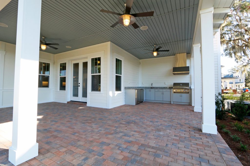 Mid-sized elegant backyard brick patio kitchen photo in Orlando with a roof extension