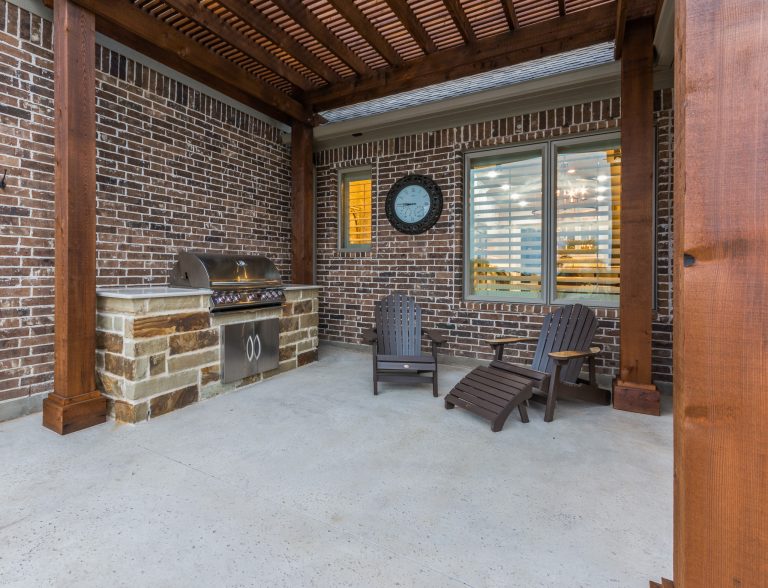 Mid-sized elegant backyard concrete patio kitchen photo in Dallas with a pergola