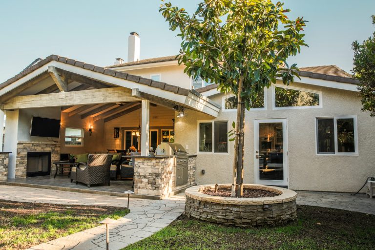 Mid-sized elegant backyard patio kitchen photo in Los Angeles with a roof extension and decking