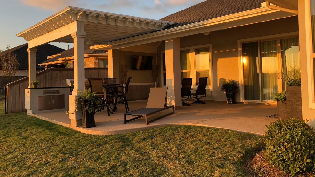 Mid-sized elegant backyard stamped concrete patio kitchen photo in Houston with a pergola