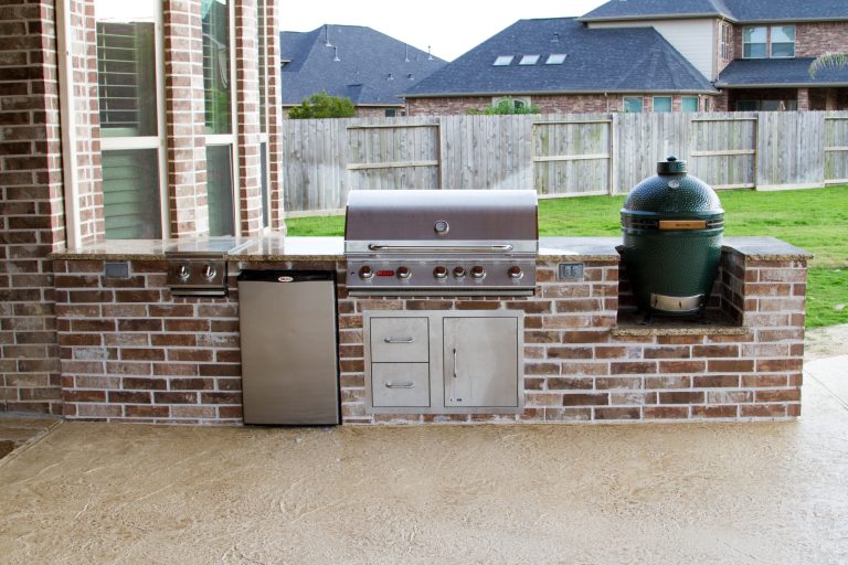 Mid-sized elegant backyard stone patio kitchen photo in Houston with a roof extension
