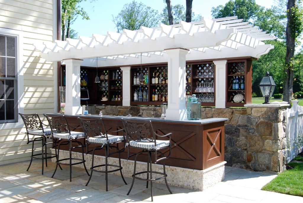 Mid-sized elegant backyard stone patio kitchen photo in New York with a pergola