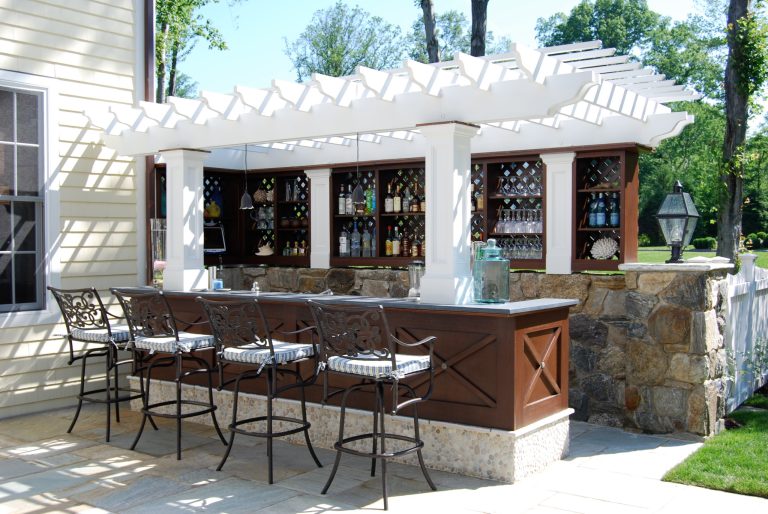 Mid-sized elegant backyard stone patio kitchen photo in New York with a pergola