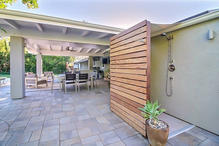 Mid-sized elegant backyard stone patio kitchen photo in Orange County with a roof extension