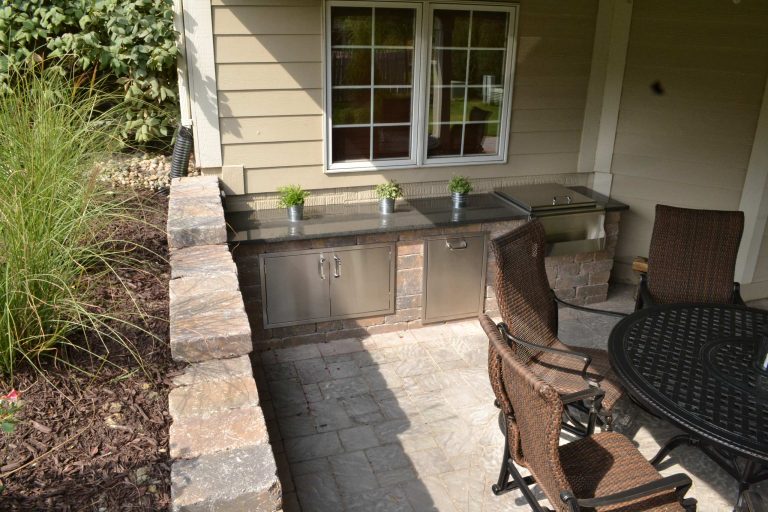 Mid-sized elegant backyard stone patio kitchen photo in Other with a roof extension