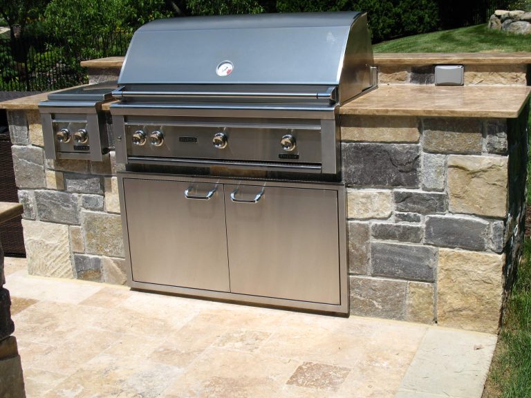 Mid-sized elegant backyard stone patio kitchen photo in Other with no cover