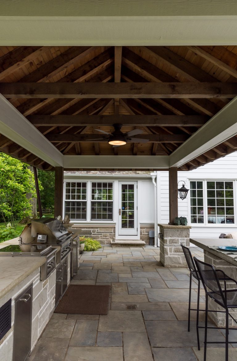 Mid-sized elegant backyard stone patio kitchen photo with a gazebo