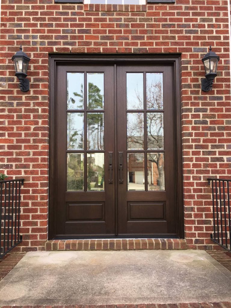 Mid-sized elegant brick front porch photo in Raleigh with a roof extension by Southern Custom Doors | Outdoor Photos | Porch | Landscaping | Landscape Design | Outdoor Living Space | Porch Design Ideas | Outdoor Living Space Ideas | Backyard Design