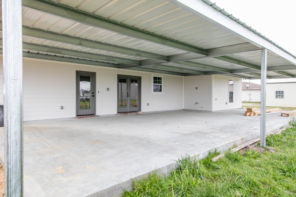 Mid-sized elegant concrete back porch photo in New Orleans with an awning by Manuel Builders, LLC | Outdoor Photos | Porch | Landscaping | Landscape Design | Outdoor Living Space | Porch Design Ideas | Outdoor Living Space Ideas | Backyard Design