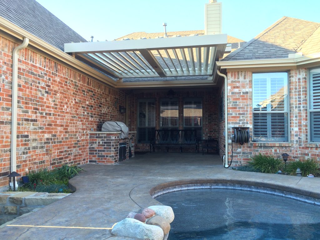 Mid-sized elegant side yard concrete patio kitchen photo in Dallas with a pergola
