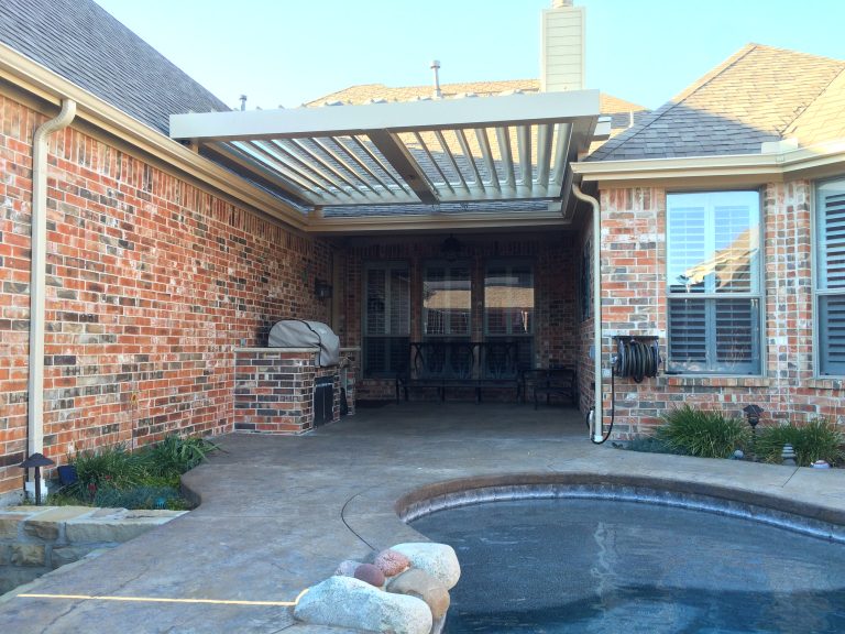 Mid-sized elegant side yard concrete patio kitchen photo in Dallas with a pergola