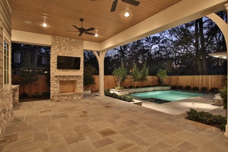 Mid-sized elegant stone front porch photo in Houston with a roof extension by Trinity Estate Homes, Ltd. | Outdoor Photos | Porch | Landscaping | Landscape Design | Outdoor Living Space | Porch Design Ideas | Outdoor Living Space Ideas | Backyard Design